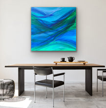 Load image into Gallery viewer, Dining room with a large abstract painting of blue and green on the wall above a wooden table.
