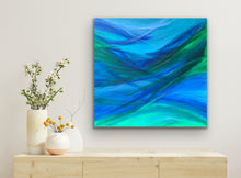 Load image into Gallery viewer, Abstract painting of blue and green waves on a wall above a wooden console table with decorative items.