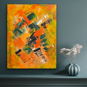 Abstract painting with orange, yellow, and green colors on a dark gray wall, next to a vase with white flowers.