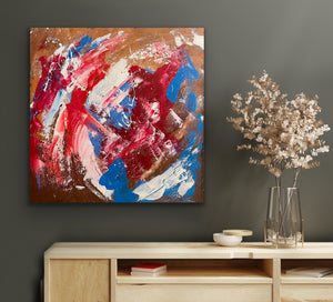 Abstract painting with red, blue, and white on a brown background, displayed on a wall above a wooden cabinet.