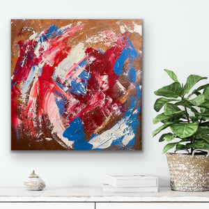 Abstract painting with red, blue, and white on a wall above a shelf with decor items and a plant.