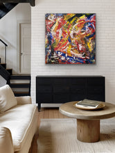 Load image into Gallery viewer, Living room with a colorful abstract painting on the wall, black dresser, and beige sofa.